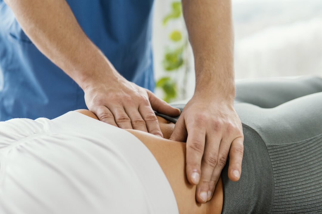 male osteopathic therapist checking female patient s abdomen